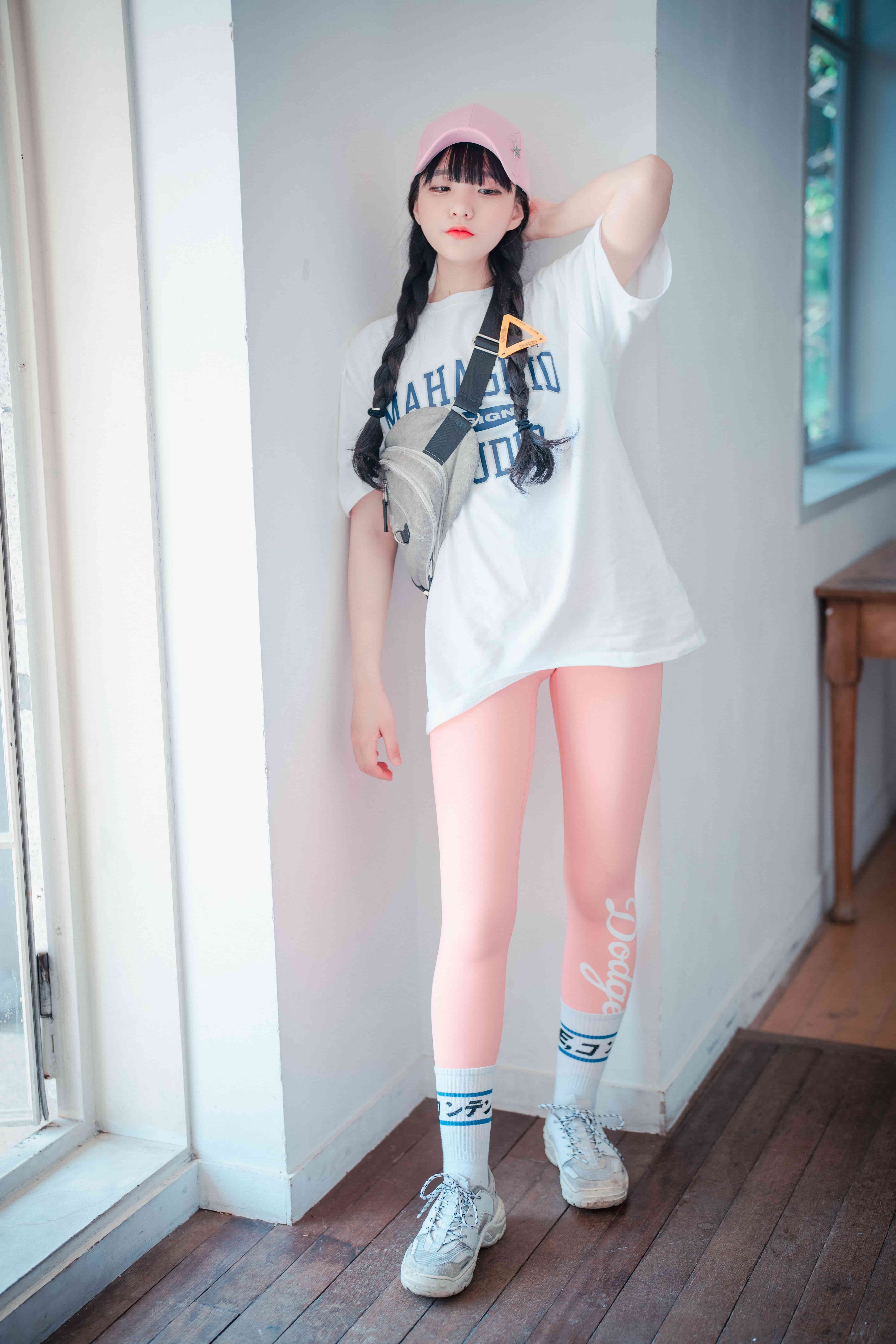 Intimate close-up of feet in pink hosiery, one leg with snug nylon, the other with a softly bunched cuff and exposed heel.